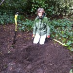 Volunteer with freshly dug hole waiting for the new sapling to be planted.